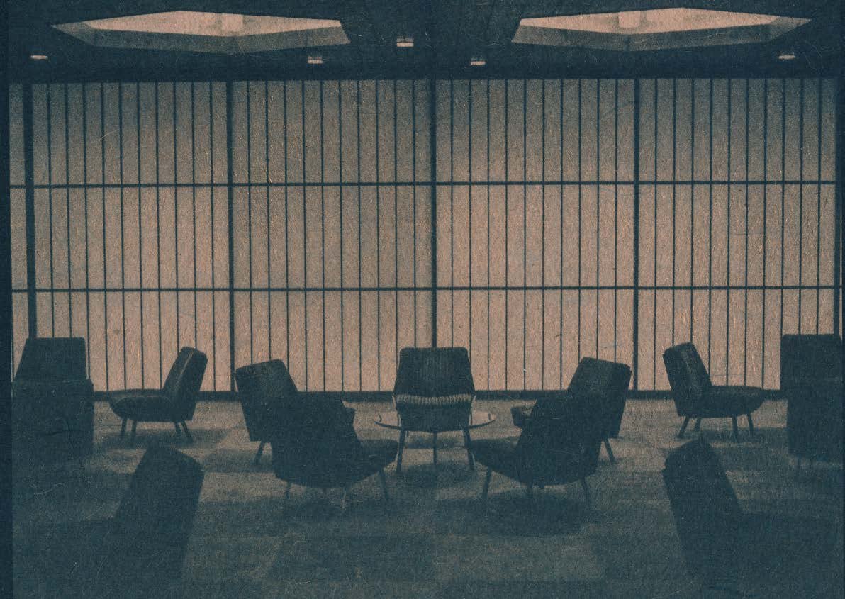 A 1950s-style lounge of chairs behind a slatted screen, blue-toned print